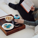 A black Wrapsulator Slim holding a slim can on a tray with popcorn and cookies
