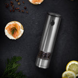 Pepper grinder with sliced lemon and pepper on a dark surface