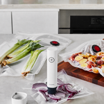ZWILLING vacuum pump sealing bags of onions, leeks, and potatoes on a kitchen counter